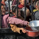 Children try to get food relief in the southern Gaza Strip city of Rafah, on December 31, 2023. Rizek Abdeljawad/Xinhua/Getty Images